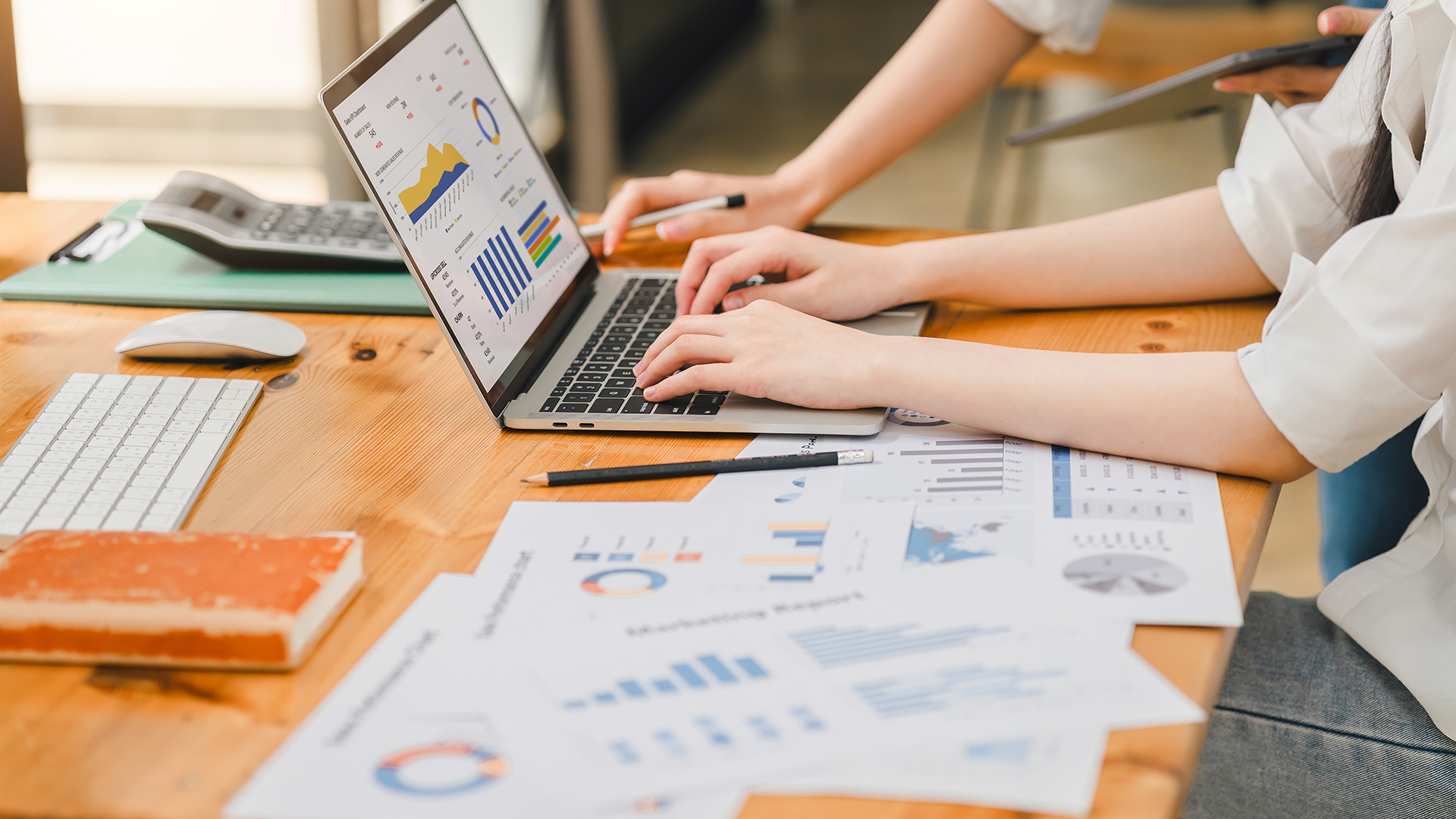 Professional working intensively on a financial analysis with colorful charts and data spreadsheets displayed on a laptop. Professional working on colorful charts and data spreadsheets displayed on a laptop.