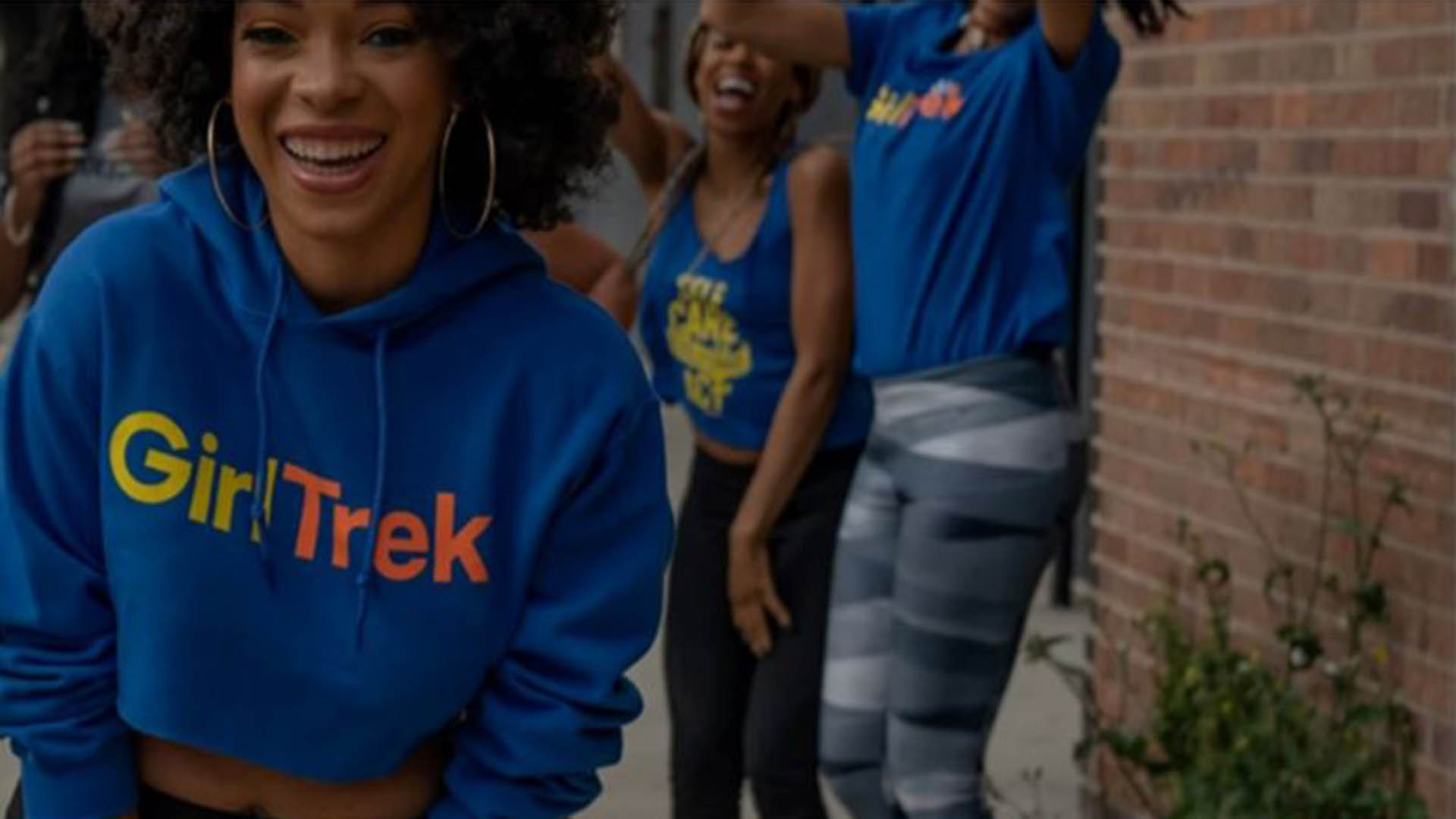 girltrek-oct-2024 GirlTrek, image of women of color in blue sweatshirts outdoors smiling and celebrating